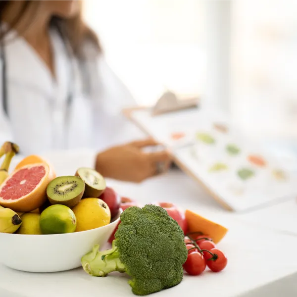 Dottoressa nutrizionista mostra un piano alimentare accanto a frutta e verdura