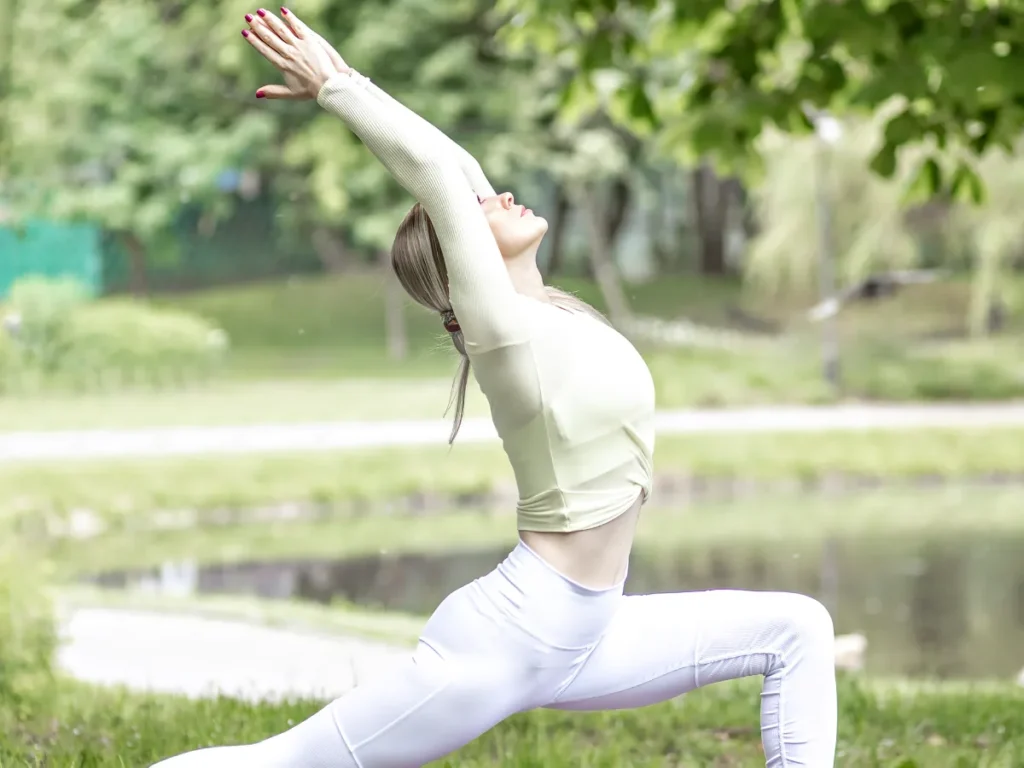 Donna che pratica yoga all’aperto in una posizione di allungamento